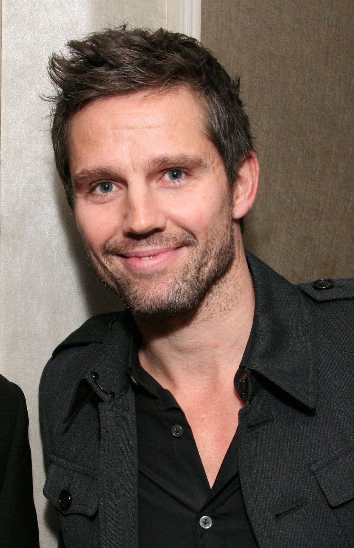 Jason Orange smiles for a photo in a black shirt