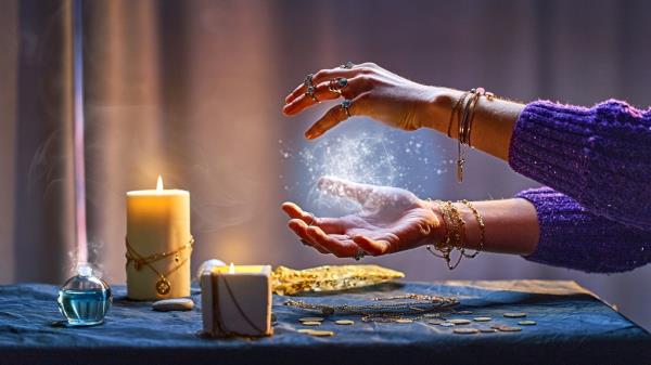 Magical luminous swirling glowing ball in the palm of a witch wizard woman